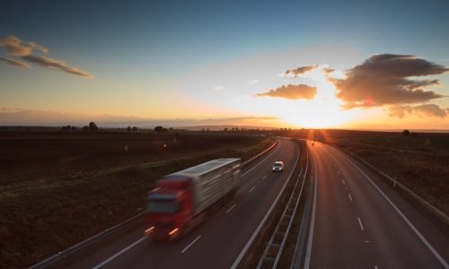 highway traffic - motion blurred truck on a highway/motorway/speedway at dusk (color toned image)